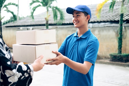 Woman receiving package from delivery man. Delivery, mail, people and shipping concept.