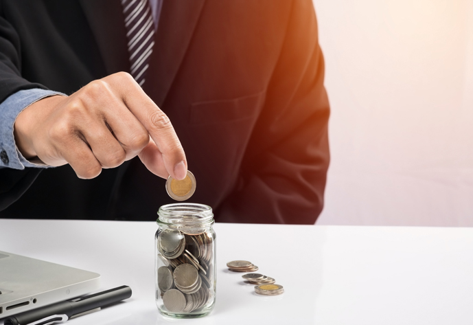 Hand putting mix coins and seed in clear bottle and copyspace, Business investment growth concept.