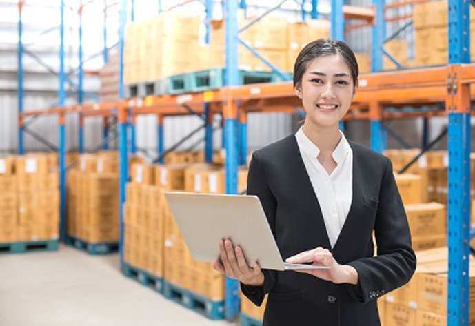 Business woman holding laptop with smiling at warehouse. People working concept.